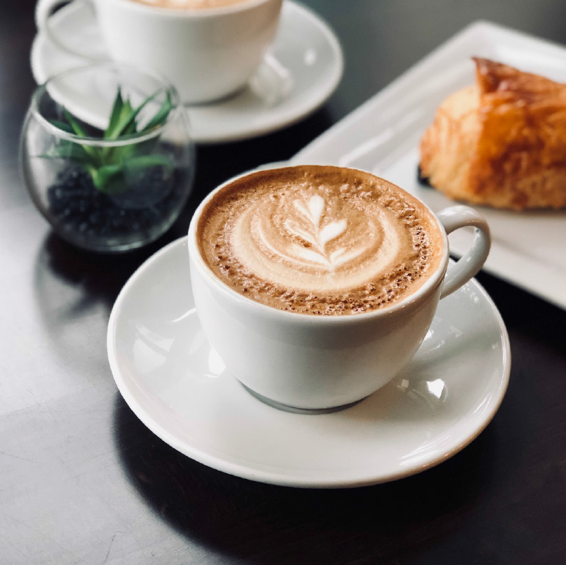 Cup of delicious coffee with froth on breakfast in cafeteria