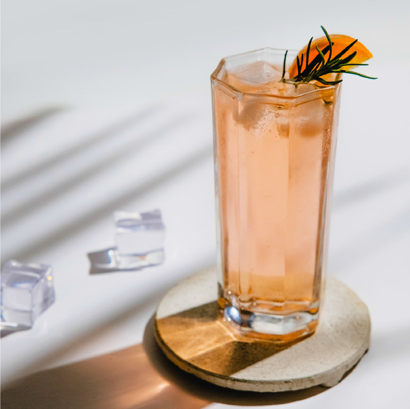Glass of drink with ice cubes on white background